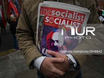 A member of the Socialist Party holds a latest Socialist Alternative paper, as Hundreds of people including SIPTU unions, Right2Work campaig...