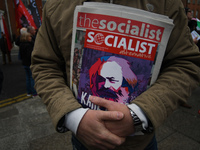 A member of the Socialist Party holds a latest Socialist Alternative paper, as Hundreds of people including SIPTU unions, Right2Work campaig...