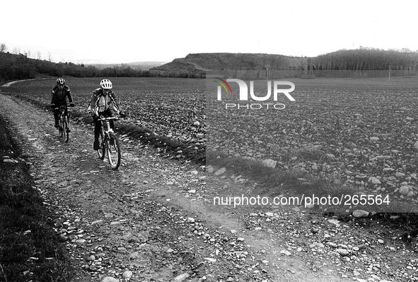 Two cyclists pilgrims on the journey to Santiago de Compostela running to Alto del Perdòn, in Zariquiegui, Spain, on December 2004  