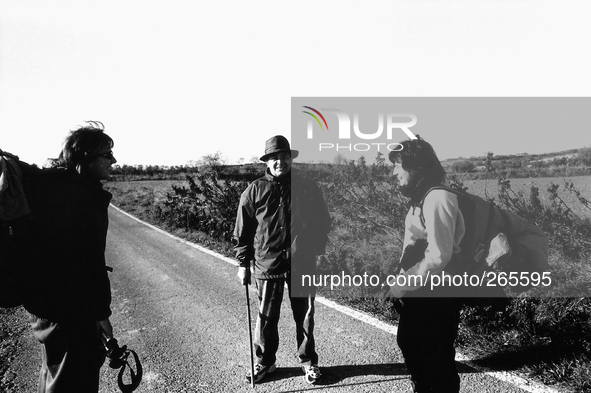 Two pilgrims asking for information on the path of the road to Santiago because of a long detour on the highway, near Torres del Rio, Spain,...