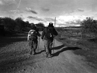 Two Spanish pilgrims climbing  the small height of the Crucero de Santo Toribio, in Santibanes Veldeiglesias, Spain, on December 2004 (