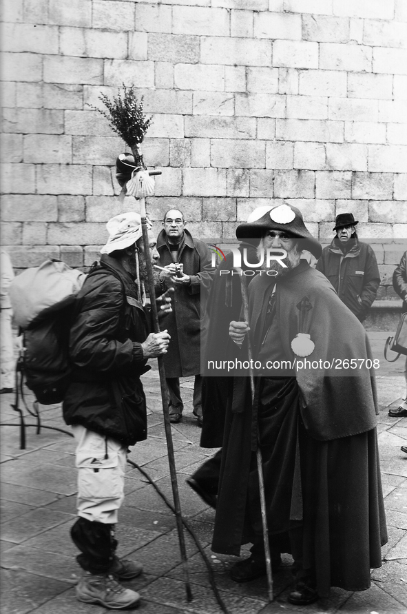 Piligrims just arrived at the destination mingle with an old pilgrim who dress up in medieval, in Santiago de Compostela, Spain, on December...