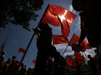 Supporters of Sri Lankan Marxist political party, People's Liberation Front, shout slogans while holding flags during a parade march held to...