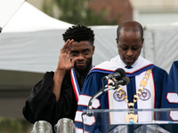 (L-R): Actor and alumnus Chadwick Boseman listens to Howard University President Dr. Wayne A.I. Frederick read his bio, at the commencement...