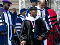 Actor and alumnus Chadwick Boseman (R), and behind him Howard University President Wayne A.I. Frederick, leave Howard University's commencem...