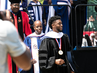 Actor and alumnus Chadwick Boseman (R), and behind him Howard University President Wayne A.I. Frederick, leave Howard University's commencem...