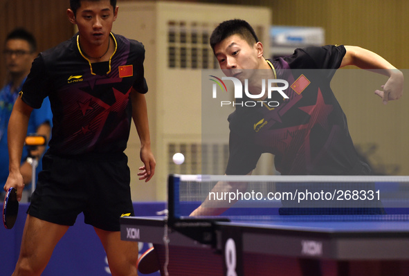 (141001) -- INCHEON, Oct. 1, 2014 () -- Ma Long (R) and Zhang Jike of China compete during the men's doubles 1/16 elimination match of table...