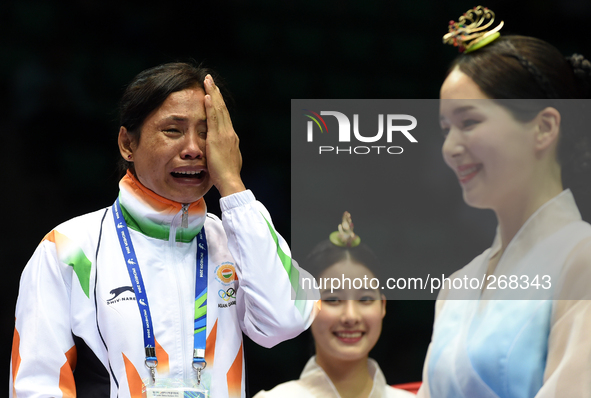 (141001) -- INCHEON, Oct. 1, 2014 () -- Devi Laishram Sarita (L) of India reacts during the awarding ceremony of the women's light (57-60kg)...