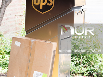 A United Parcel Service of America truck and drop-off box are seen along Milwaukee Avenue in the Old Irving Park neighborhood of Chicago, IL...