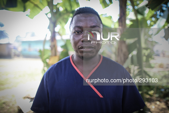 A portrait of Moses Massaquoi, 25, a hygenist who works in the Island Clinic Ebola Treatment Unit. This photo was taken after he had worn PP...