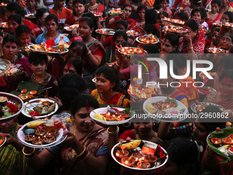 Hindu devotees offer prayer hold lamps as they attend a ritual named Bipodnashini Puja that Puja against evil and danger at street of Dhaka...