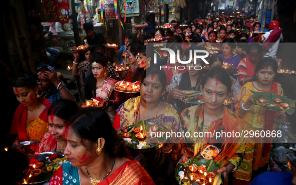 Hindu devotees offer prayer hold lamps as they attend a ritual named Bipodnashini Puja that Puja against evil and danger at street of Dhaka...