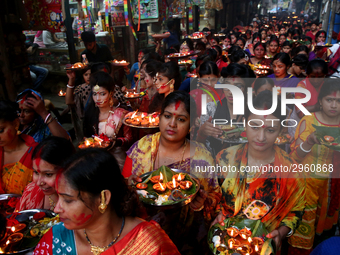 Hindu devotees offer prayer hold lamps as they attend a ritual named Bipodnashini Puja that Puja against evil and danger at street of Dhaka...