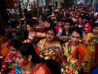 Hindu devotees offer prayer hold lamps as they attend a ritual named Bipodnashini Puja that Puja against evil and danger at street of Dhaka...