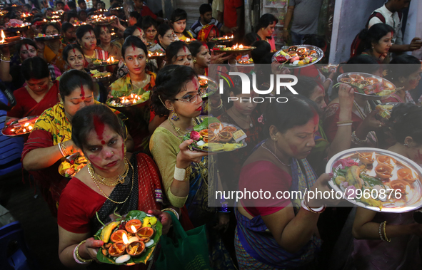 Hindu devotees offer prayer hold lamps as they attend a ritual named Bipodnashini Puja that Puja against evil and danger at street of Dhaka...