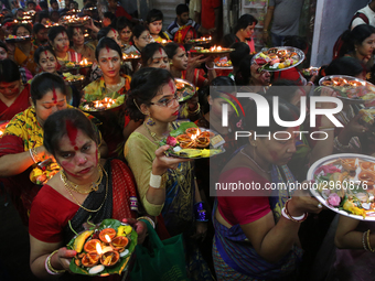 Hindu devotees offer prayer hold lamps as they attend a ritual named Bipodnashini Puja that Puja against evil and danger at street of Dhaka...