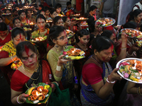 Hindu devotees offer prayer hold lamps as they attend a ritual named Bipodnashini Puja that Puja against evil and danger at street of Dhaka...