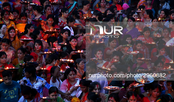 Hindu devotees offer prayer hold lamps as they attend a ritual named Bipodnashini Puja that Puja against evil and danger at street of Dhaka...