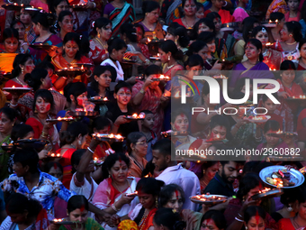 Hindu devotees offer prayer hold lamps as they attend a ritual named Bipodnashini Puja that Puja against evil and danger at street of Dhaka...