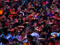 Hindu devotees offer prayer hold lamps as they attend a ritual named Bipodnashini Puja that Puja against evil and danger at street of Dhaka...