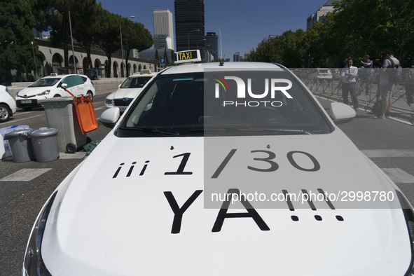 taxis block an avenue amid a strike by cabbies in Madrid on July 31, 2018. - Taxi drivers across Spain kept striking against ride-hailing co...