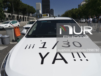 taxis block an avenue amid a strike by cabbies in Madrid on July 31, 2018. - Taxi drivers across Spain kept striking against ride-hailing co...