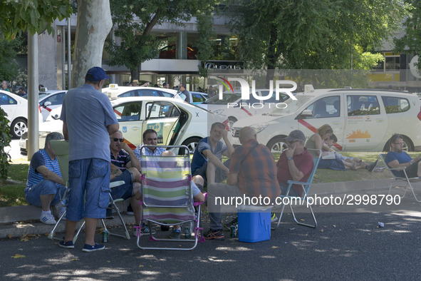 taxis block an avenue amid a strike by cabbies in Madrid on July 31, 2018. - Taxi drivers across Spain kept striking against ride-hailing co...