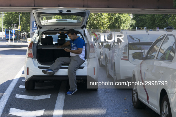 taxis block an avenue amid a strike by cabbies in Madrid on July 31, 2018. - Taxi drivers across Spain kept striking against ride-hailing co...