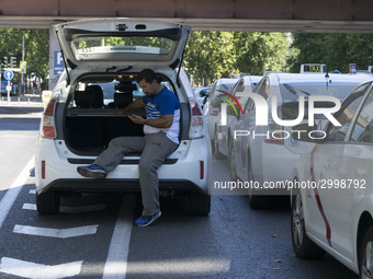 taxis block an avenue amid a strike by cabbies in Madrid on July 31, 2018. - Taxi drivers across Spain kept striking against ride-hailing co...