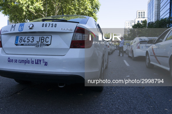 taxis block an avenue amid a strike by cabbies in Madrid on July 31, 2018. - Taxi drivers across Spain kept striking against ride-hailing co...