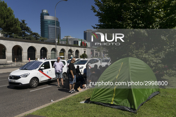 taxis block an avenue amid a strike by cabbies in Madrid on July 31, 2018. - Taxi drivers across Spain kept striking against ride-hailing co...