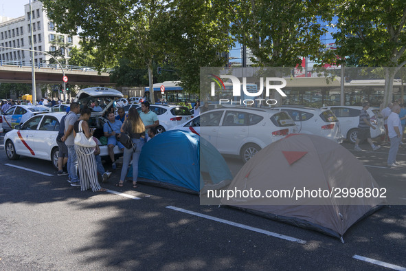 taxis block an avenue amid a strike by cabbies in Madrid on July 31, 2018. - Taxi drivers across Spain kept striking against ride-hailing co...