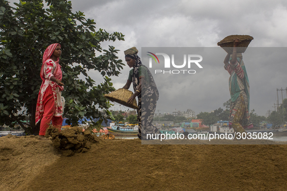 Women during the Day labors are working in a domestic port in Dhaka, Bangladesh, on 14 August 2018. 