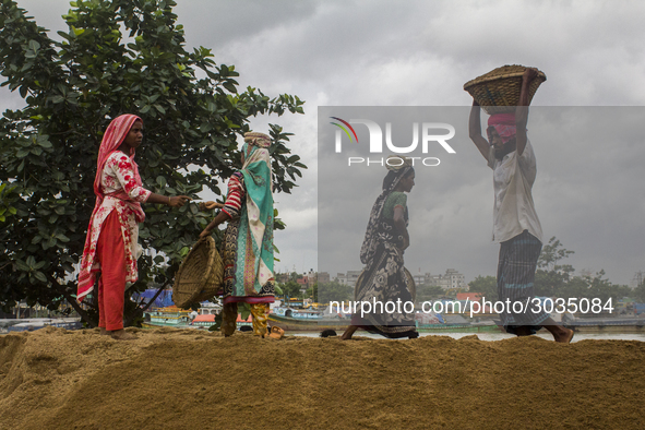 Women during the Day labors are working in a domestic port in Dhaka, Bangladesh, on 14 August 2018. 