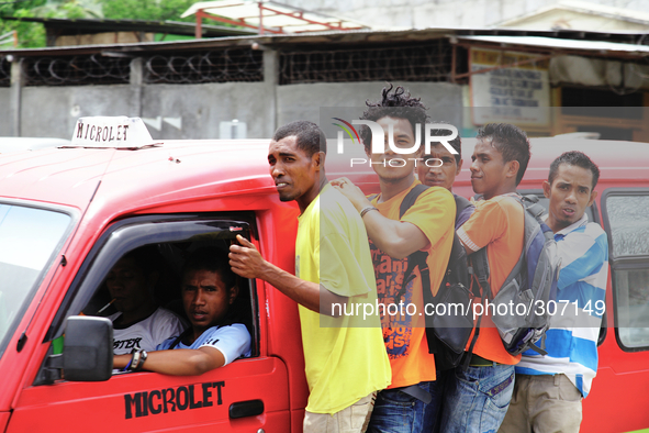 Timor Leste uni students hitching a ride on a Microlet leading Dili for the districts. 