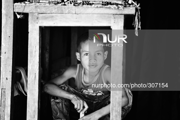 Timorese boy hiding under a table to escape Timor Leste's searing heat. 