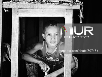 Timorese boy hiding under a table to escape Timor Leste's searing heat. (