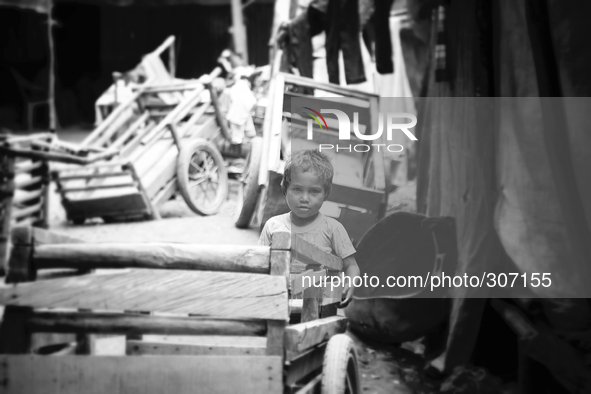 A young child playing with carts at a Dili market. 