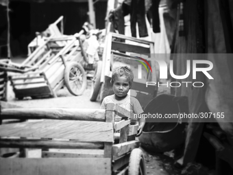 A young child playing with carts at a Dili market. (