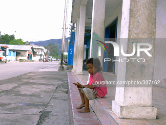 A young girl in the poor neighbourhood of Culuhun sits by the roadside. (