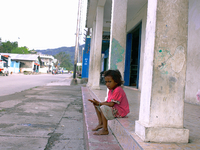 A young girl in the poor neighbourhood of Culuhun sits by the roadside. (