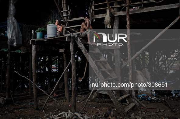 Kampong Pluk, Tonle Sap, Cambodia. A man sits on the steps of his families’ house soon to be submerged by the lake. For most of the year the...