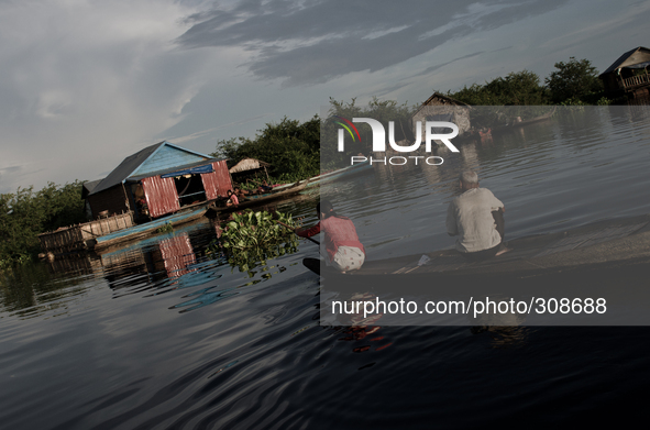 Phumi Moat Khla, Tonle Sap, Cambodia. Villagers return to their homes afloat in the middle of South East Asia's largest freshwater and over...