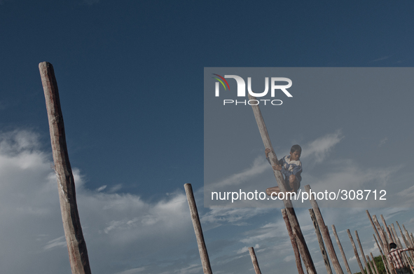 Kampong Pluk, Tonle Sap, Cambodia. A young boy climbs the posts of a half finished pier during the last days of the monsoon season.

The T...