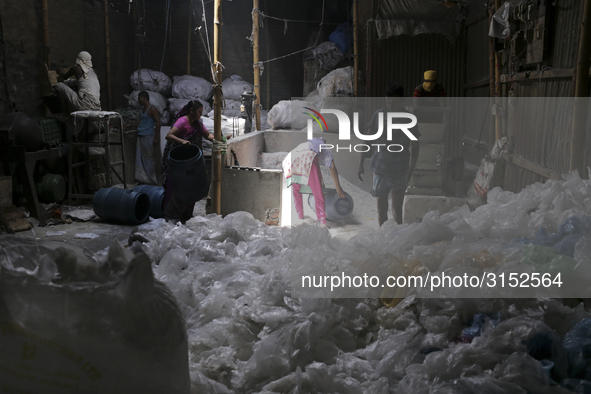 Women work in a polythene bag recycling factory in Kamrangirchar, Dhaka Bangladesh, on September 14, 2018. 