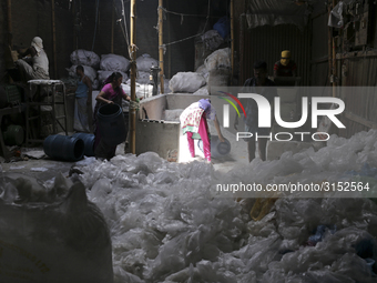 Women work in a polythene bag recycling factory in Kamrangirchar, Dhaka Bangladesh, on September 14, 2018. (