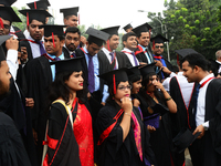 A group of graduates expressing their delight in front of the sculpture Raju at TSC area, on the 51th convocation of the students of Dhaka U...