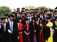 A group of graduates expressing their delight in front of the sculpture Raju at TSC area, on the 51th convocation of the students of Dhaka U...