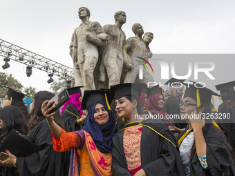 A group of graduates expressing their delight in front of the sculpture Raju at TSC area, on the 51th convocation of the students of Dhaka U...