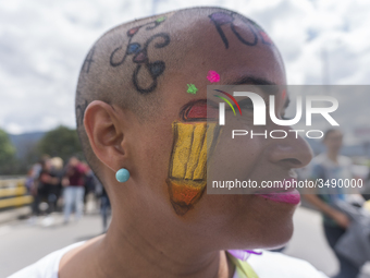 A woman with drawings alluding to education participates in the march of students for public education in Bogota, Colombia, on 28 November 2...